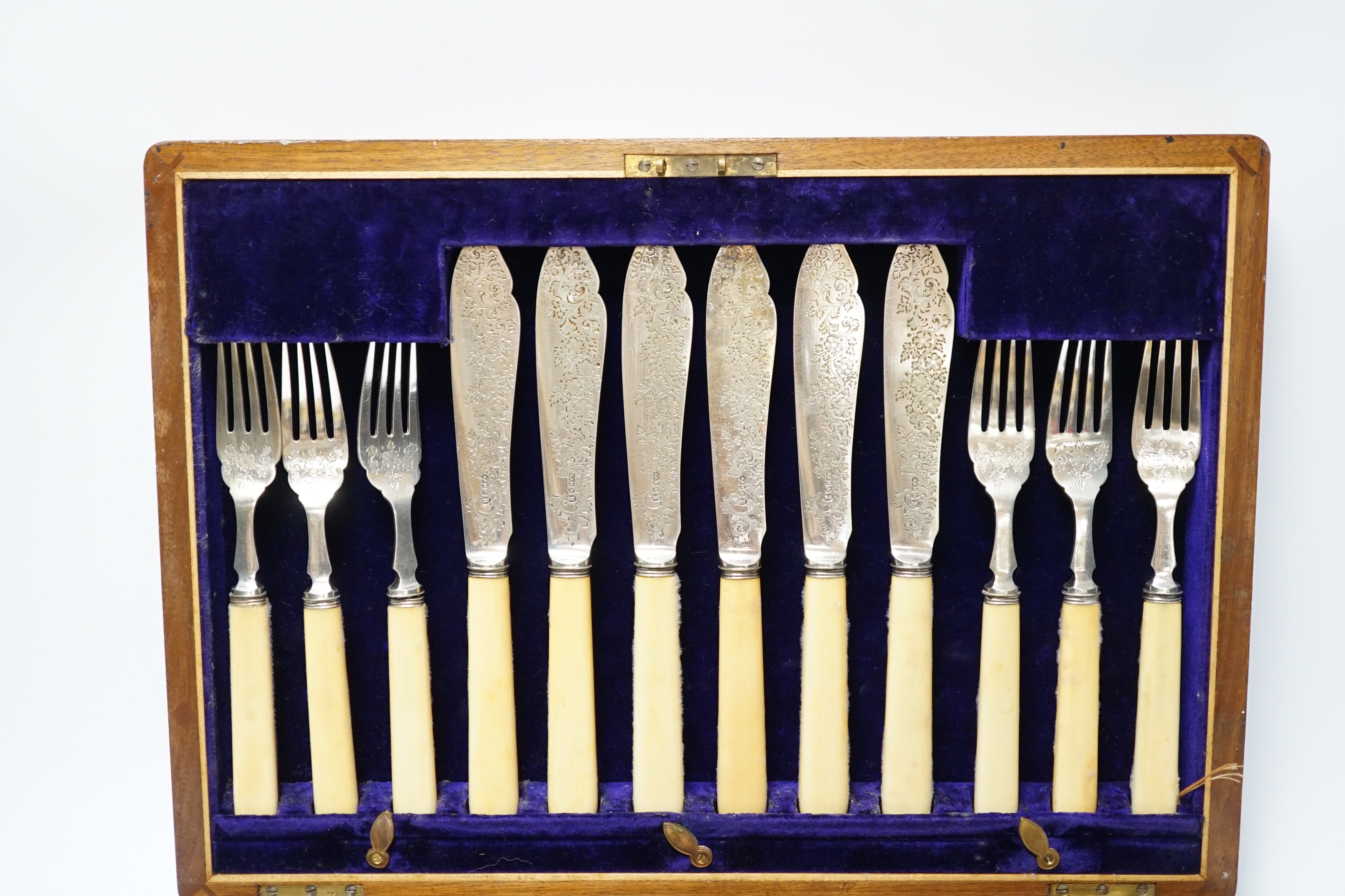 A set of twelve plated engraved fish knives and forks, with bone handles, cased together with a pair of plated fish servers with ivorine handles